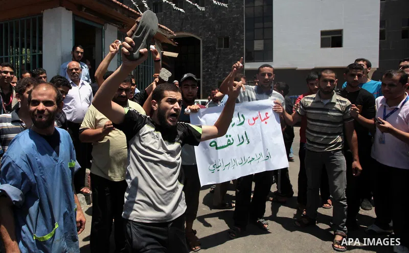 Palestinian protesters shout slogans during a protest against the Palestinian President Mahmoud Abbas and the unity government ministers, outside al-Shifa hospital in Gaza City on July 15, 2014. Palestinian President Mah...