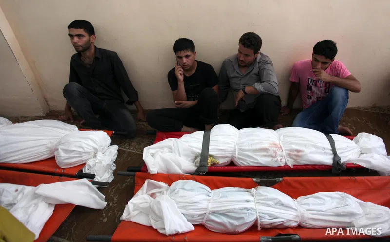 Palestinian mourners mourn over the bodies of four members of the Al-Astal family, who were killed following an Israeli air strike which took place before a five-hour humanitarian truce, during a funeral in Khan Younis i...