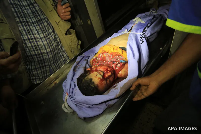 Palestinian relatives mourn over the body of a boy killed by an Israeli air strike at a morgue in al-Shifa hospital, in Gaza City on July 18, 2014. Israel stepped up its land offensive in Gaza with artillery, tanks and g...