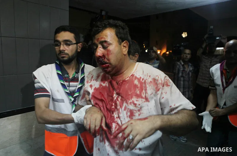 Palestinians and medics carry a man, who medics said was wounded in Israeli shelling, at a hospital in Gaza City July 20, 2014. Israel said on Sunday it had expanded its ground offensive in Gaza and militants kept up roc...