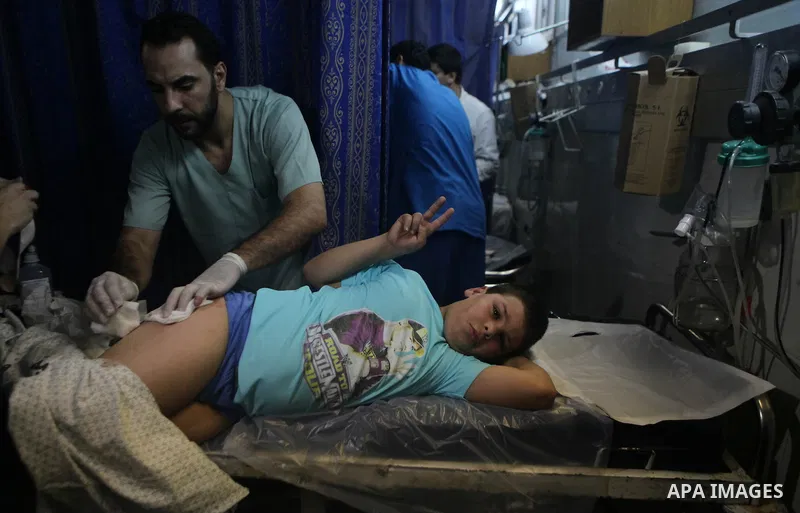 Palestinians and medics carry a boy, who medics said was wounded in Israeli shelling, at a hospital in Gaza City July 20, 2014. Israel said on Sunday it had expanded its ground offensive in Gaza and militants kept up roc...