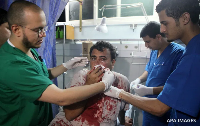 Palestinians and medics carry a man, who medics said was wounded in Israeli shelling, at a hospital in Gaza City July 20, 2014. Israel said on Sunday it had expanded its ground offensive in Gaza and militants kept up roc...