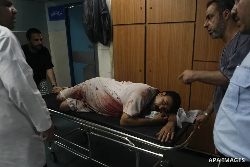 Palestinians and medics carry a man, who medics said was wounded in Israeli shelling, at a hospital in Gaza City July 20, 2014. Israel said on Sunday it had expanded its ground offensive in Gaza and militants kept up roc...