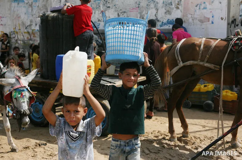 Palestinians fill bottles and containers with water from a public tap in in Khan Yunis, in the southern Gaza Strip July 21, 2014. Israeli forces killed at least 10 Palestinian militants on Monday after they crossed the b...