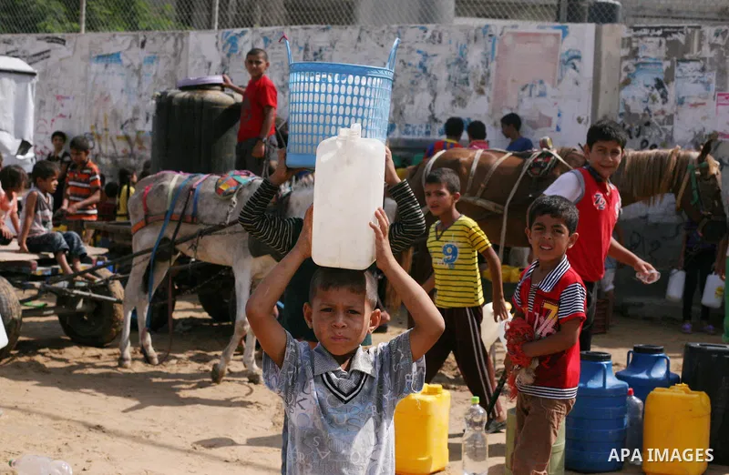 Palestinians fill bottles and containers with water from a public tap in in Khan Yunis, in the southern Gaza Strip July 21, 2014. Israeli forces killed at least 10 Palestinian militants on Monday after they crossed the b...
