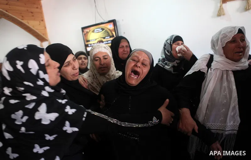 Palestinian relatives mourn during the funeral of Mahmoud al-Shawamreh in the West Bank town of Al-Ram near Jerusalem July 22, 2014. Israeli troops shot dead al-Shawamreh during clashes with stone-throwers in the occupie...