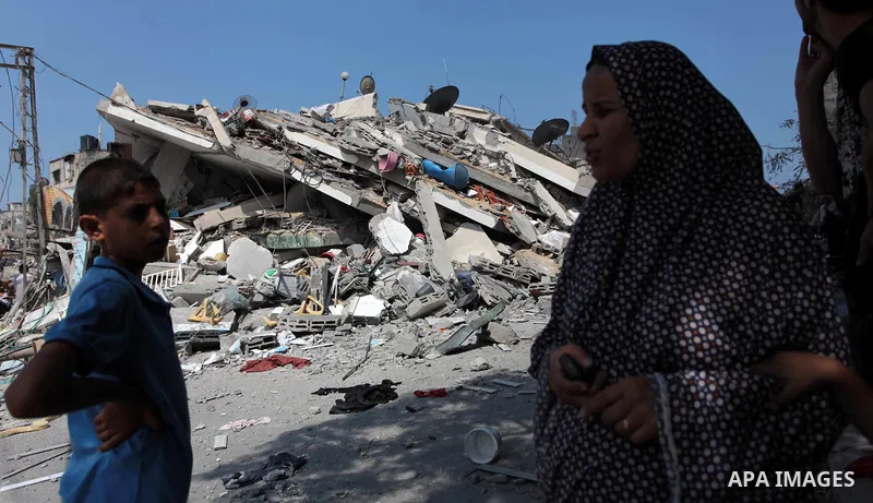 A Palestinian woman stands in front of the rubble of a residential building, which police said was destroyed in an Israeli air strike, in Gaza City July 22, 2014. Israel kept up its assaults in the Gaza Strip on Tuesday,...