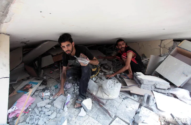 Palestinians search in the rubble of a residential building, which police said was destroyed in an Israeli air strike, in Gaza City July 22, 2014. Israel kept up its assaults in the Gaza Strip on Tuesday, killing three P...