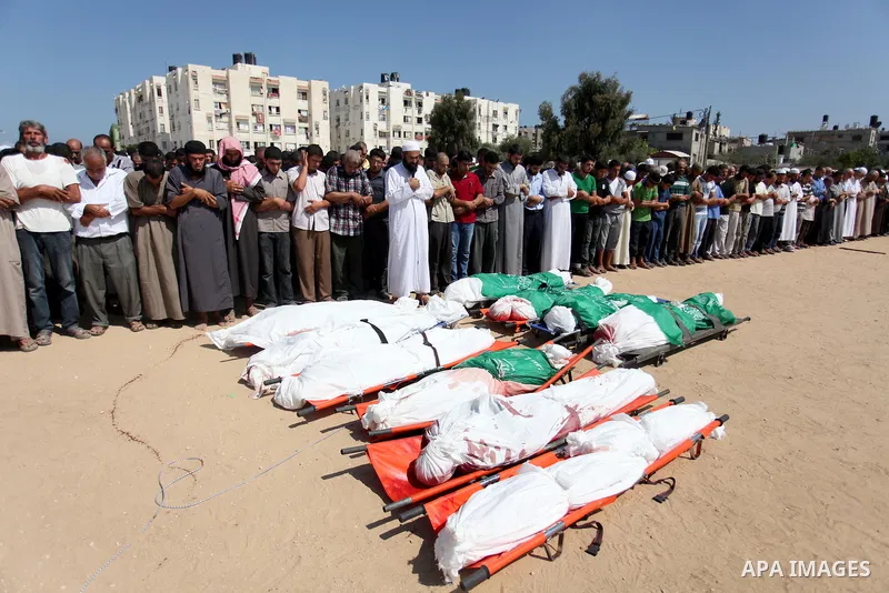 Palestinians pray over the bodies of 11 member of al-Astal family, who were killed in an Israeli air strike, during their funeral in Khan Younis in the southern Gaza Strip, July 24, 2014. Hamas rejected a ceasefire the p...