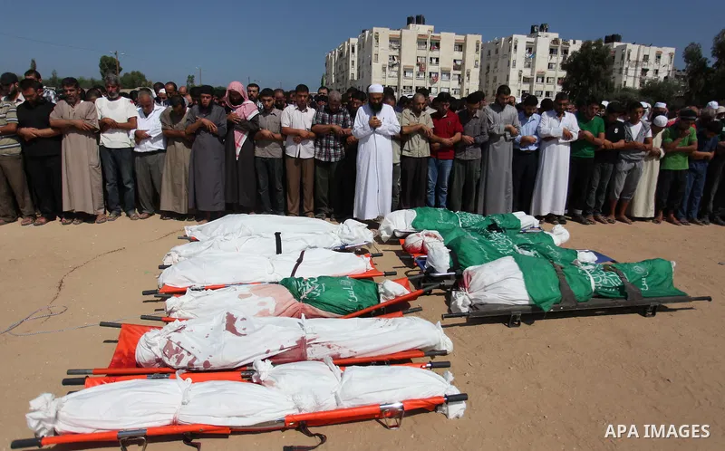 Palestinians pray over the bodies of 11 member of al-Astal family, who were killed in an Israeli air strike, during their funeral in Khan Younis in the southern Gaza Strip, July 24, 2014. Hamas rejected a ceasefire the p...
