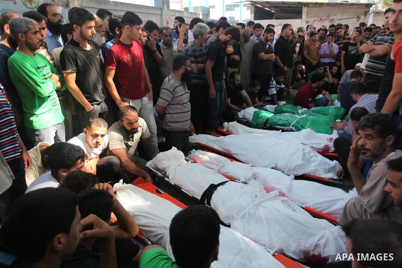 Palestinians gather around the bodies of 11 member of al-Astal family, who were killed in an Israeli air strike, during their funeral in Khan Younis in the southern Gaza Strip, July 24, 2014. Hamas rejected a ceasefire t...