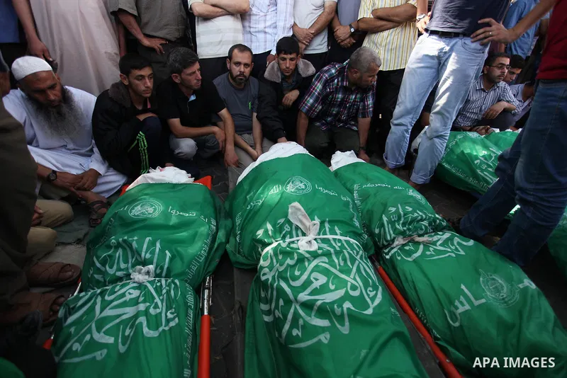 Palestinians gather around the bodies of 11 member of al-Astal family, who were killed in an Israeli air strike, during their funeral in Khan Younis in the southern Gaza Strip, July 24, 2014. Hamas rejected a ceasefire t...
