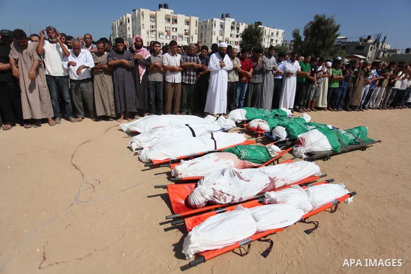 Palestinians pray over the bodies of 11 member of al-Astal family, who were killed in an Israeli air strike, during their funeral in Khan Younis in the southern Gaza Strip, July 24, 2014. Hamas rejected a ceasefire the p...