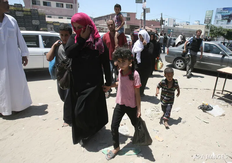 Palestinians flee their houses from Israeli shelling during an Israeli ground offensive east of Khan Younis in the southern Gaza Strip July 24, 2014. Israel won a partial reprieve from the economic pain of its Gaza war o...