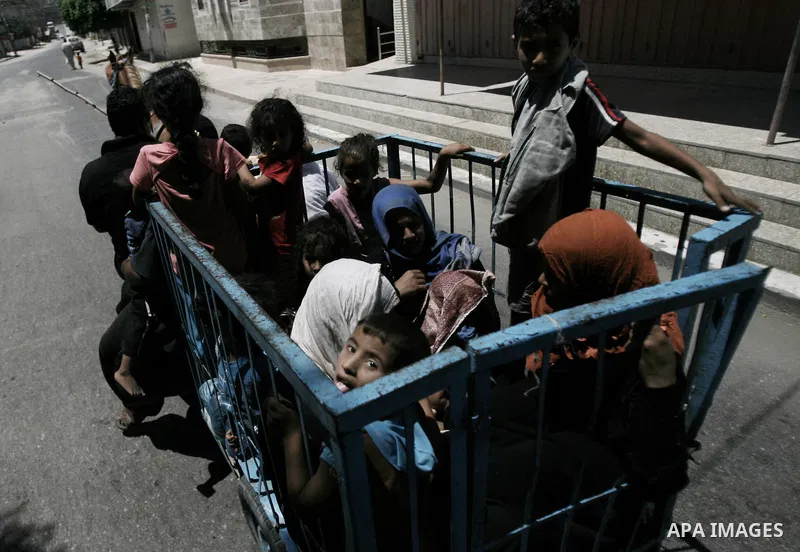 Palestinians ride in a tricycle as they flee their houses from Israeli shelling during an Israeli ground offensive east of Khan Younis in the southern Gaza Strip July 24, 2014. Israel won a partial reprieve from the econ...