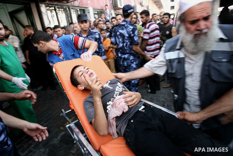 Palestinians wheel a stretcher transporting a boy, who medics said was wounded by an Israeli air strike, at a hospital in Khan Younis in the southern Gaza Strip July 24, 2014. Israel won a partial reprieve from the econo...