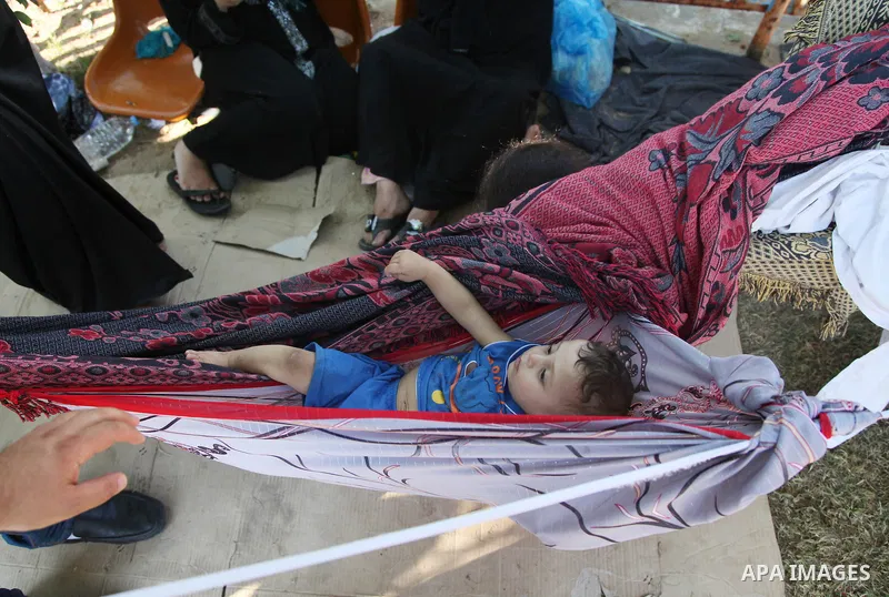 Displaced Palestinians from the Shuja'iyya neighbourhood gather at Al-Shifa hospital in Gaza City, on July 24, 2014.. Photo by Ezz al-Zanoun