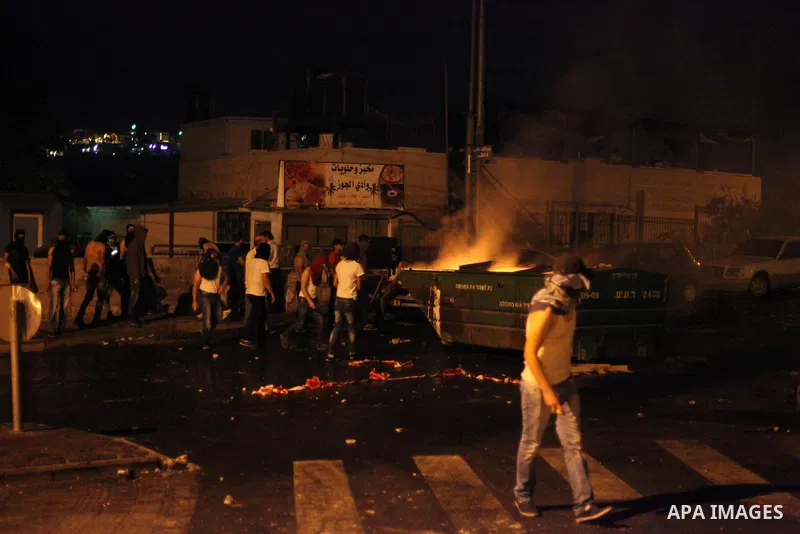 Palestinian protesters throw stones at Israeli policemen as they barring entrance to the al-Aqsa mosque to men younger than 50 years, to mark Laylat al-Qadr, or Night of Destiny, in Jerusalem's Old City on July 24, 2014....