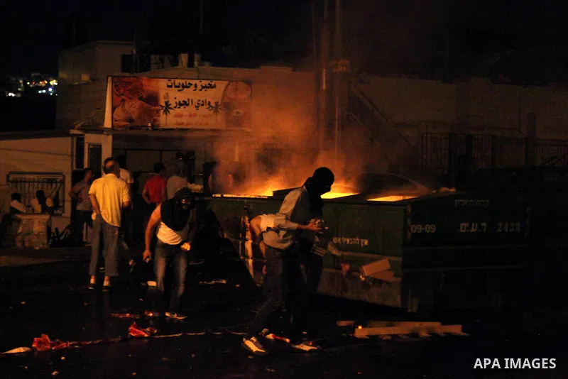 Palestinian protesters throw stones at Israeli policemen as they barring entrance to the al-Aqsa mosque to men younger than 50 years, to mark Laylat al-Qadr, or Night of Destiny, in Jerusalem's Old City on July 24, 2014....