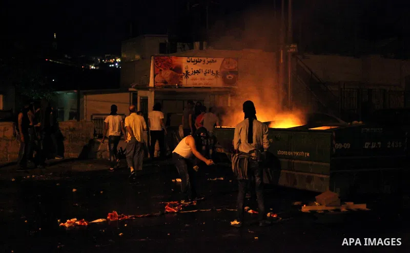 Palestinian protesters throw stones at Israeli policemen as they barring entrance to the al-Aqsa mosque to men younger than 50 years, to mark Laylat al-Qadr, or Night of Destiny, in Jerusalem's Old City on July 24, 2014....