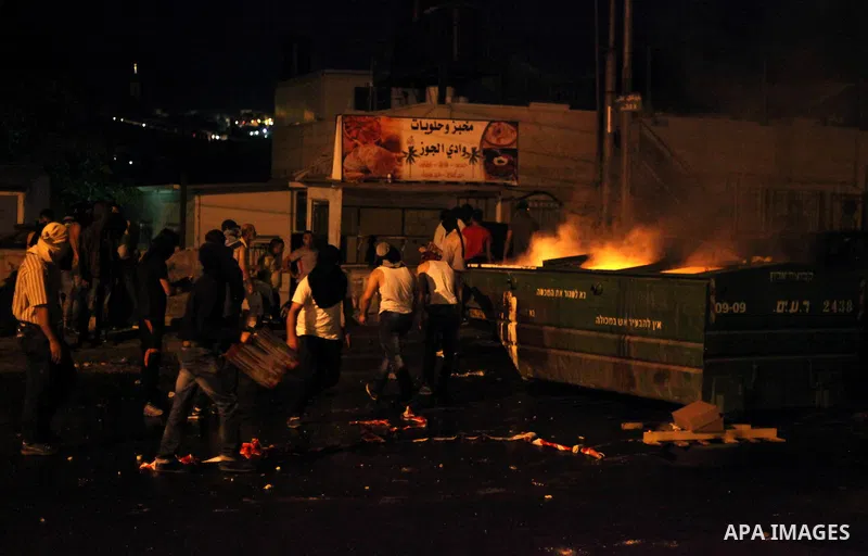Palestinian protesters throw stones at Israeli policemen as they barring entrance to the al-Aqsa mosque to men younger than 50 years, to mark Laylat al-Qadr, or Night of Destiny, in Jerusalem's Old City on July 24, 2014....
