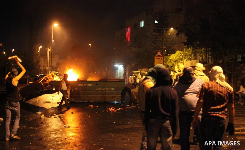 Palestinian protesters throw stones at Israeli policemen as they barring entrance to the al-Aqsa mosque to men younger than 50 years, to mark Laylat al-Qadr, or Night of Destiny, in Jerusalem's Old City on July 24, 2014....