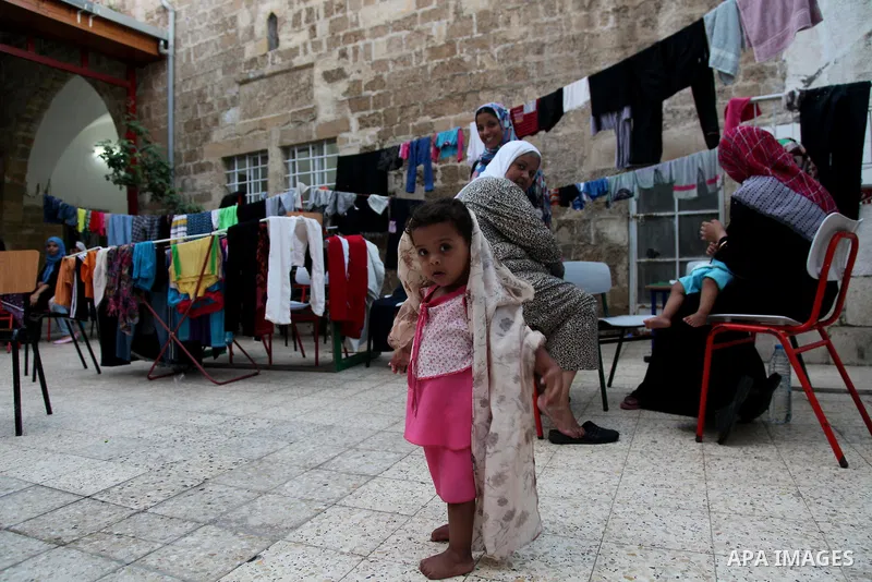Displaced Palestinian gather of Iftar meal at a Greek Orthodox church where many Palestinians are taking shelter in Gaza City on July 25, 2014. US Secretary of State John Kerry entered new meetings with UN chief Ban Ki-m...