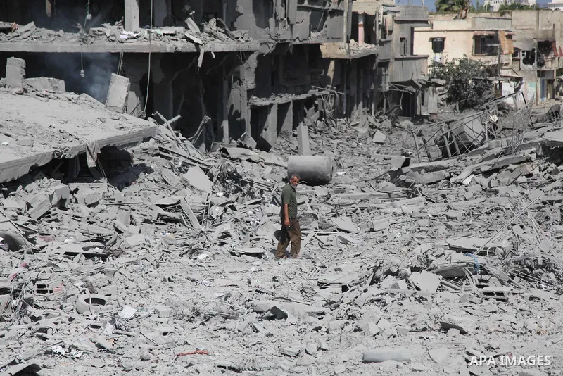 A Palestinian man walks on the rubble as he enter the northern district of Beit Hanun in the Gaza Strip during an humanitarian truce on July 26, 2014. Palestinians retrieved dozens of bodies from the rubble of Gaza homes...