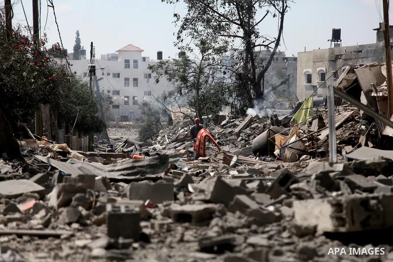 Palestinians walk on the rubble as they enter the northern district of Beit Hanun to check their homes in the Gaza Strip during an humanitarian truce on July 26, 2014. Palestinians retrieved dozens of bodies from the rub...
