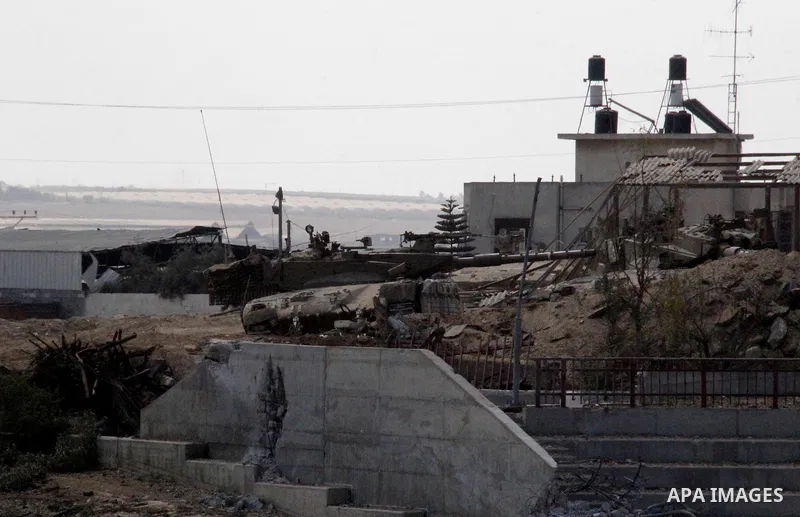 An Israeli military tank patrols amid of rubble of destroyed buildings at al-Shijaiyah district in the eastern Gaza City on July 26, 2014. Israeli troops remained in place across the Gaza Strip and continued to search fo...