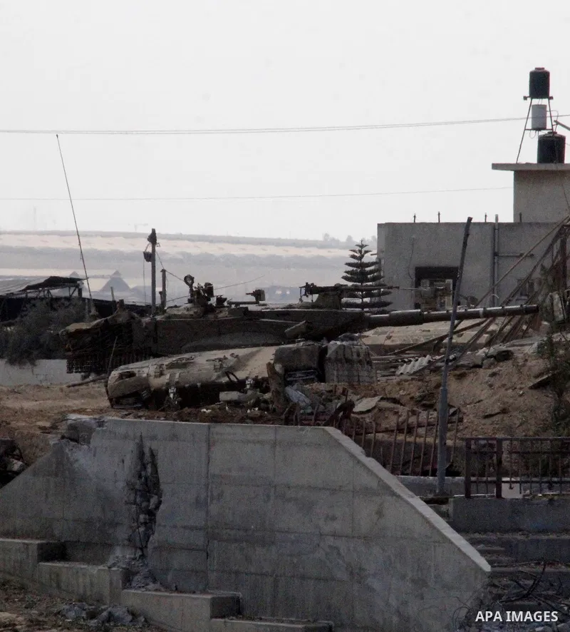 An Israeli military tank patrols amid of rubble of destroyed buildings at al-Shijaiyah district in the eastern Gaza City on July 26, 2014. Israeli troops remained in place across the Gaza Strip and continued to search fo...