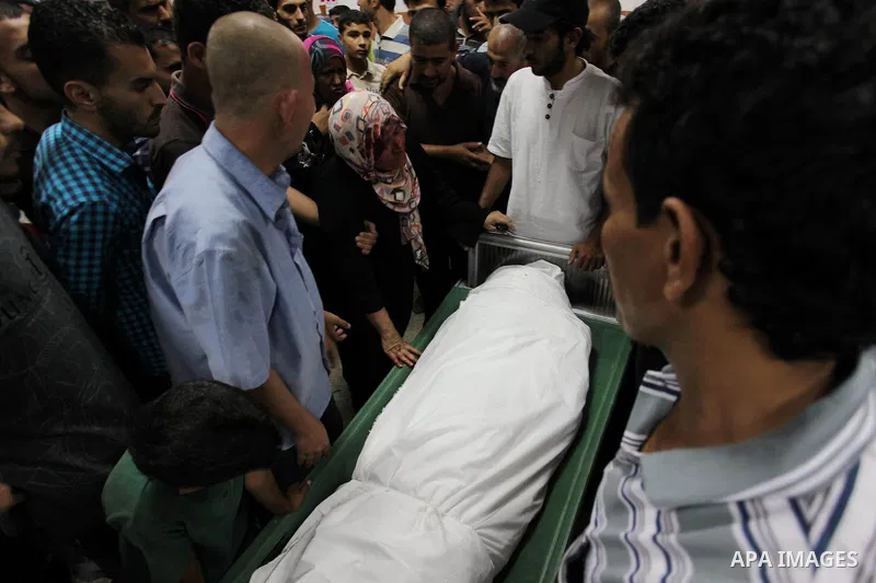 A Palestinian woman with her face covered with blood mourns her son, who was killed in an Israeli air strike, at Nasser hospital in Khan Younis in the southern Gaza Strip, July 27, 2014. Renewed Israeli raids on Gaza, wh...
