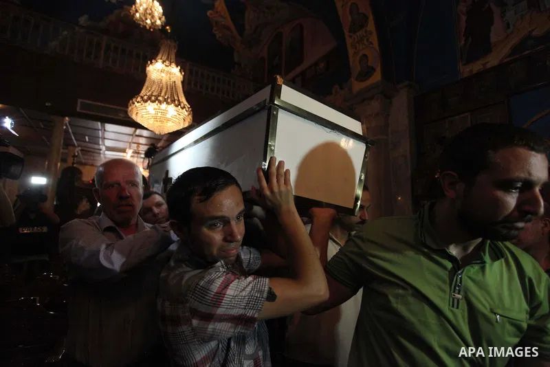Palestinian relatives and friends of Jalila Ayad, a Christian woman whose body was found under the rubble of her home after an Israeli airstike, pray over her coffin during a religious service as part of her funeral on J...