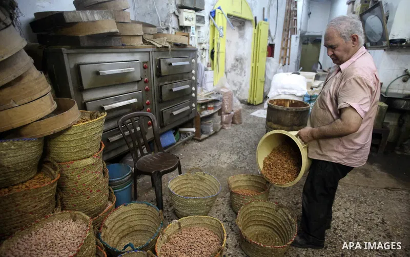 A Palestinian man prepares nuts for preparation for the upcoming Eid al-Fitr festival, at a market in Jerusalem on July 27, 2014. Eid al-Fitr festival is welcomed as a sad Eid between Palestinians as Israeli forces renew...