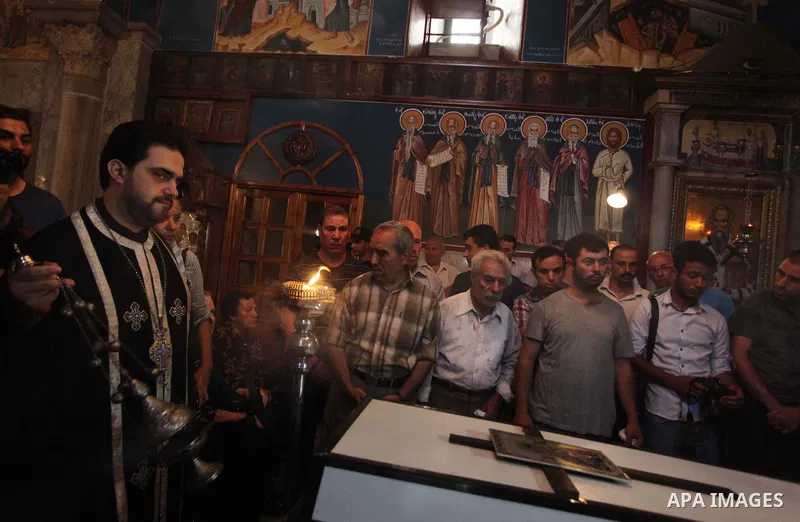 Palestinian relatives and friends of Jalila Ayad, a Christian woman whose body was found under the rubble of her home after an Israeli airstike, pray over her coffin during a religious service as part of her funeral on J...