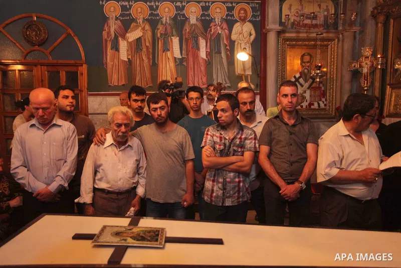 Palestinian relatives and friends of Jalila Ayad, a Christian woman whose body was found under the rubble of her home after an Israeli airstike, pray over her coffin during a religious service as part of her funeral on J...
