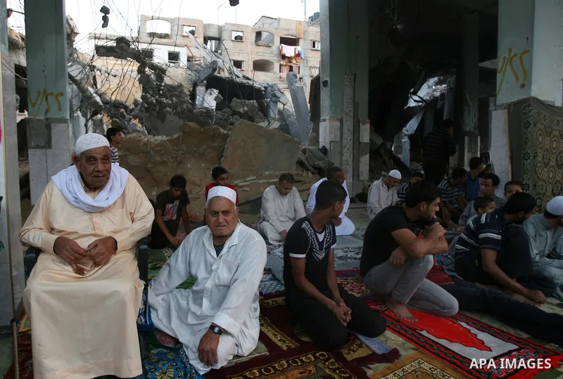 Palestinian muslims attends the Eid al-Fitr prayer at al-Farouk mosque, which witnesses said was hit by an Israeli air strike, in Rafah in the southern Gaza Strip July 28, 2014. The U.N. Security Council agreed on a stat...