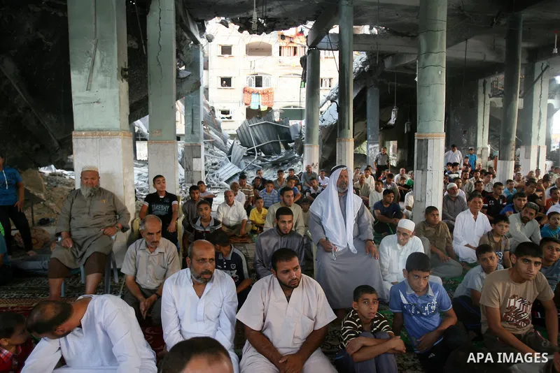 Palestinian muslims attends the Eid al-Fitr prayer at al-Farouk mosque, which witnesses said was hit by an Israeli air strike, in Rafah in the southern Gaza Strip July 28, 2014. The U.N. Security Council agreed on a stat...