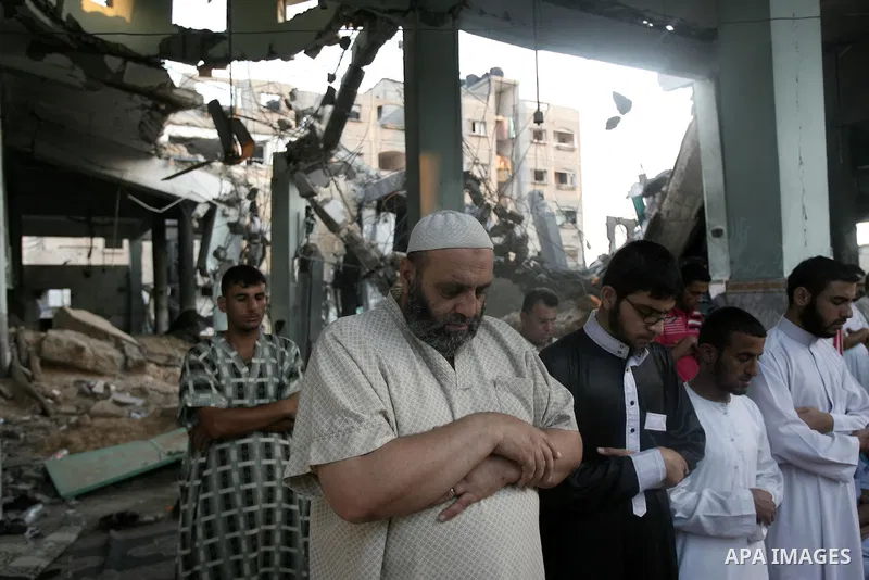 Palestinian muslims attends the Eid al-Fitr prayer at al-Farouk mosque, which witnesses said was hit by an Israeli air strike, in Rafah in the southern Gaza Strip July 28, 2014. The U.N. Security Council agreed on a stat...