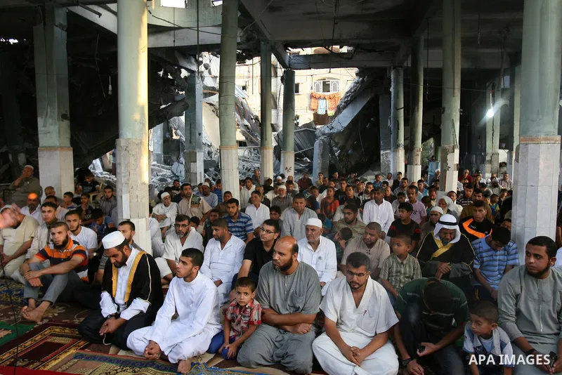 Palestinian muslims attends the Eid al-Fitr prayer at al-Farouk mosque, which witnesses said was hit by an Israeli air strike, in Rafah in the southern Gaza Strip July 28, 2014. The U.N. Security Council agreed on a stat...