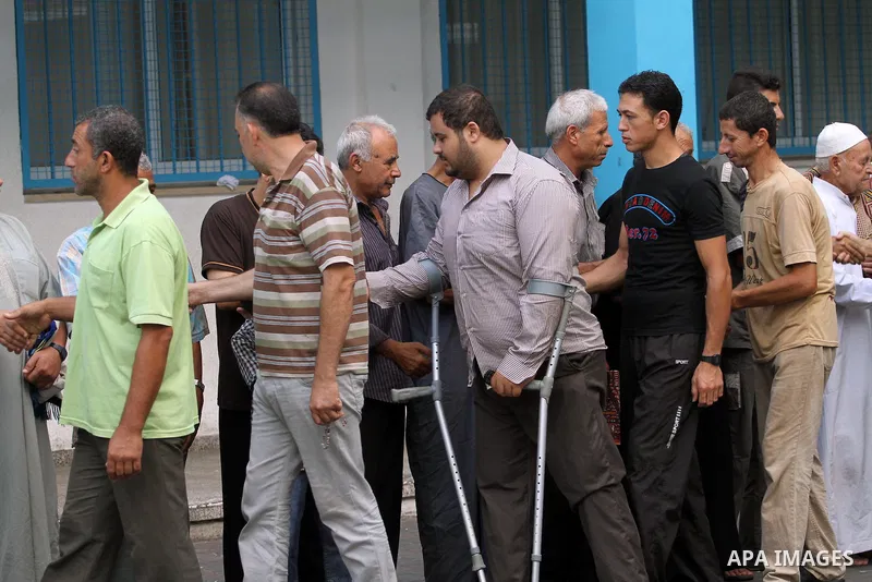 Displaced Palestinians shake hands following the Eid al-Fitr prayer at a United Nations school, in Gaza City on July 28, 2014. The U.N. Security Council agreed on a statement on Sunday urging Israel, Palestinians and Isl...