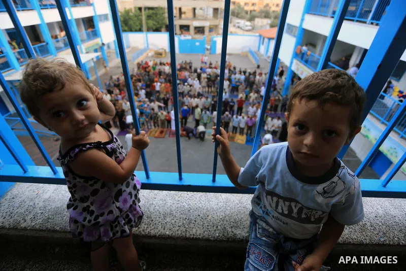 Displaced children look on as Palestinians attend the Eid al-Fitr prayer at a United Nations school, in Gaza City on July 28, 2014. The U.N. Security Council agreed on a statement on Sunday urging Israel, Palestinians an...