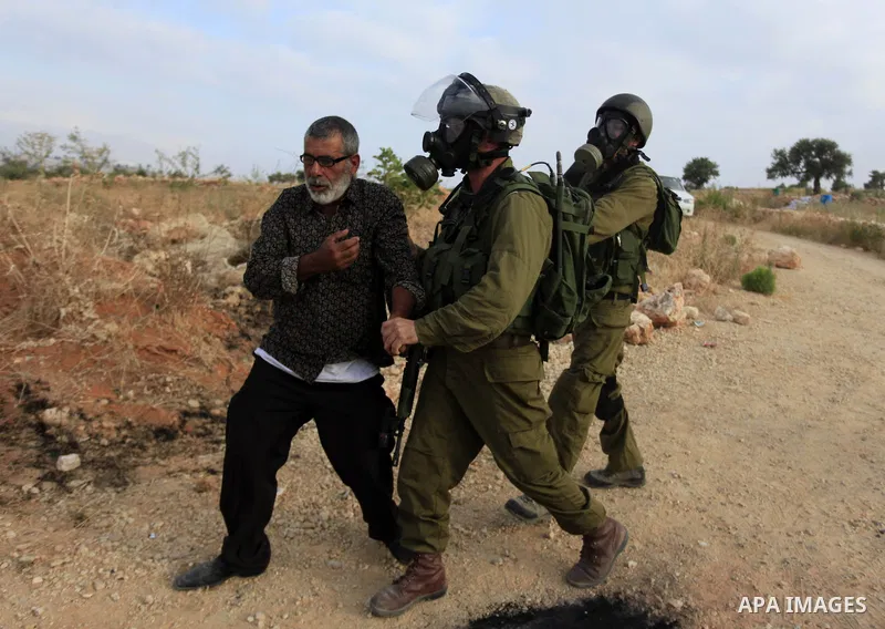 Israeli security forces detain a Palestinian protesters during clashes in following the Eid al-Fitr prayer in a protest against the Israeli military operation on Gaza Strip, in the West Bank villages of Bilin, near Ramal...