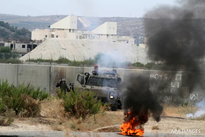 Israeli security forces fire tear gas at Palestinian protesters during clashes in following the Eid al-Fitr prayer in a protest against the Israeli military operation on Gaza Strip, in the West Bank villages of Bilin, ne...