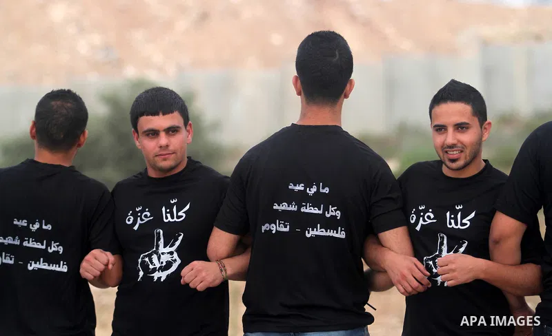 Palestinian protesters with linked hands take part in a protest against the Israeli military operation on Gaza Strip following the Eid al-Fitr prayer, in the West Bank villages of Bilin, near Ramallah on July 28, 2014. T...