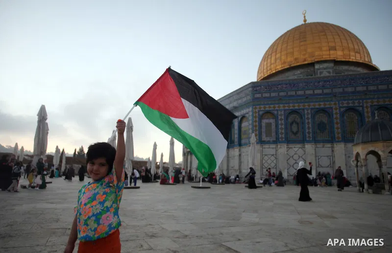 A Palestinian girl waves her national flag during the Eid al-Fitr festival at al-Aqsa mosque compound, in Jerusalem's Old City on July 28, 2014. Muslims around the world are celebrating Eid al-Fitr which marks the end of...