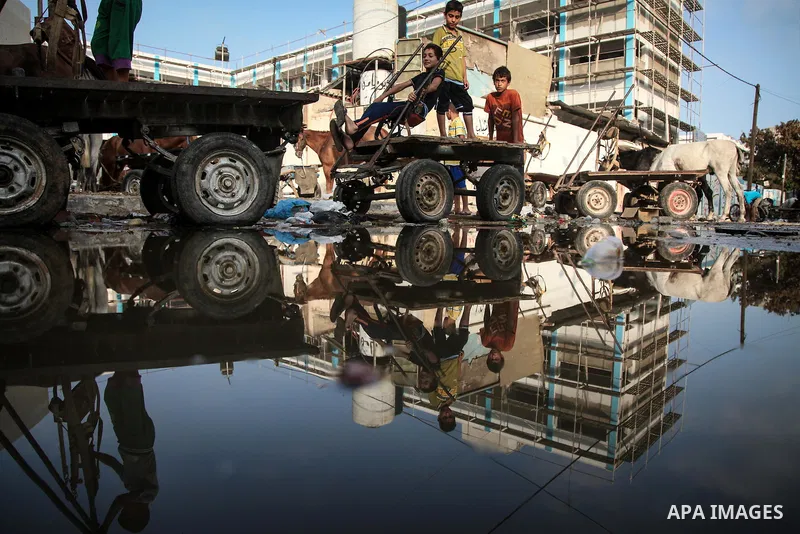 Displaced Palestinians gather at an United Nations (UN) school in Jabalia in the northern Gaza Strip, where they found refugee with their families after fleeing their homes in areas under heavy Israeli bombardment in the...