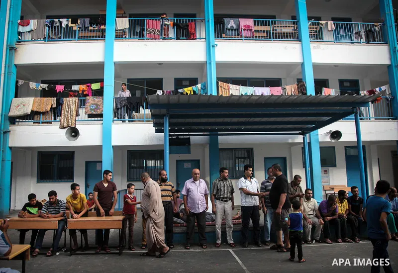 Displaced Palestinians greet each other after the morning Eid al-Fitr prayer at an United Nations (UN) school in Jabalia in the northern Gaza Strip, where they found refugee after fleeing their homes in areas under heavy...