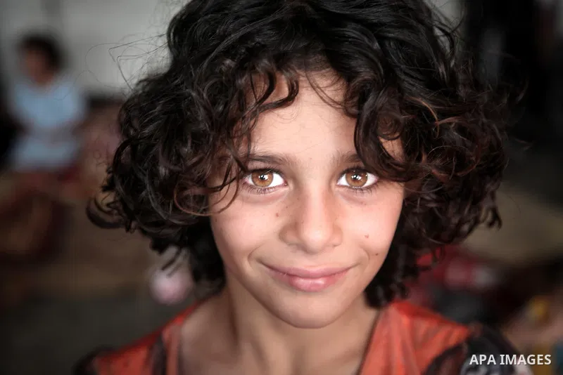 Displaced Palestinian girl stand at an United Nations (UN) school in Jabalia in the northern Gaza Strip, where they found refugee with their families after fleeing their homes in areas under heavy Israeli bombardment in...