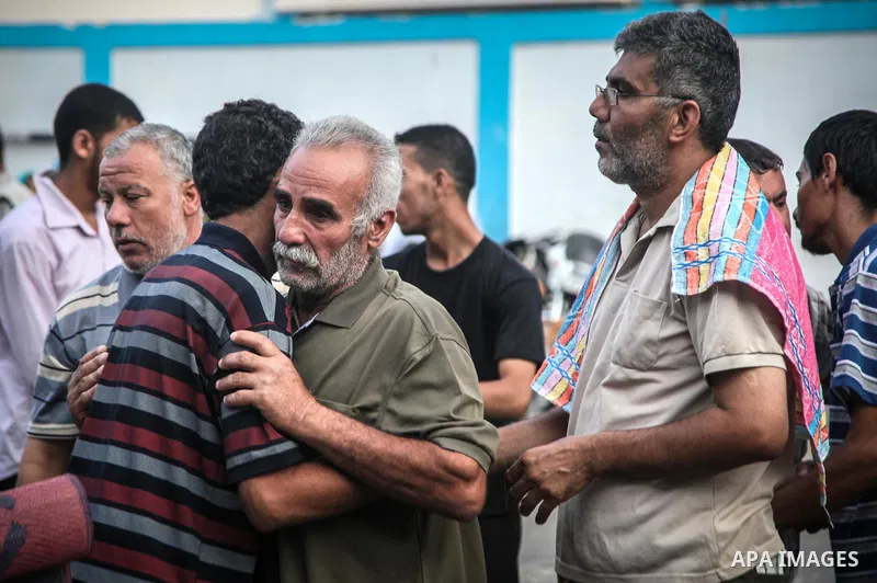 Displaced Palestinians greet each other after the morning Eid al-Fitr prayer at an United Nations (UN) school in Jabalia in the northern Gaza Strip, where they found refugee after fleeing their homes in areas under heavy...